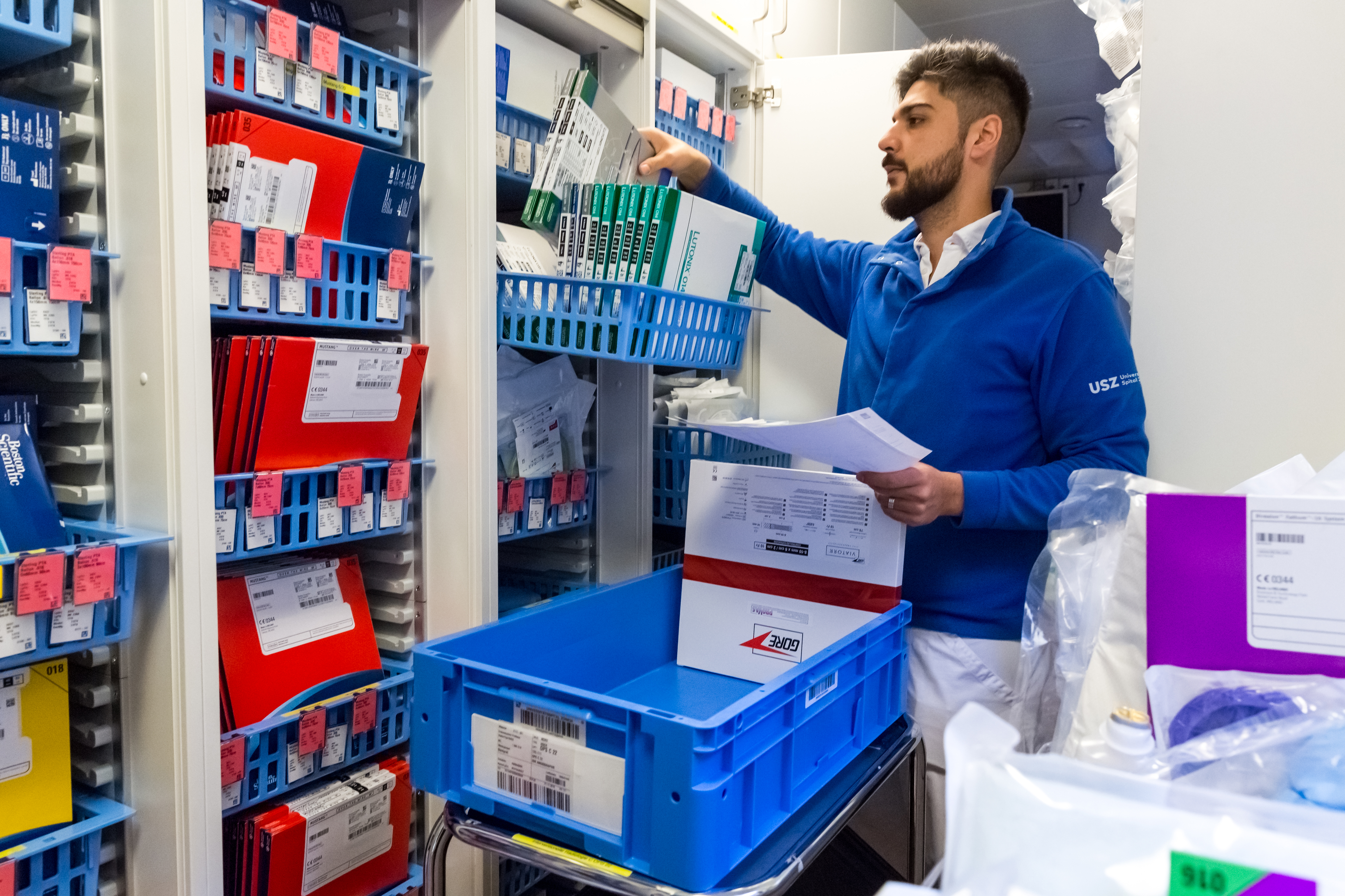 Ein Mitarbeiter der Versorgungslogistik füllt ein Stationslager des Spitals mit neuen Produkten auf. Ein Mitarbeiter der Versorgungslogistik füllt ein Stationslager des Spitals mit neuen Produkten auf.